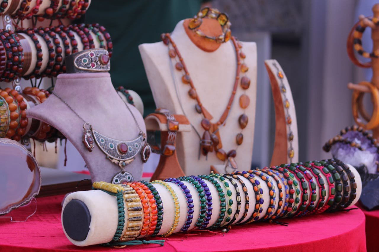 Showcase of colorful handcrafted bracelets and necklaces on soft velvet stands.
